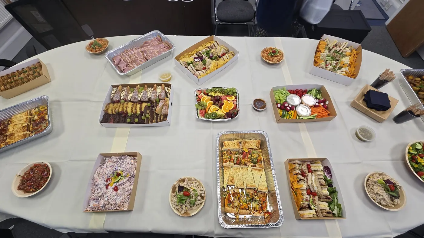 A long table laden with a variety of buffet-style food platters and salads.