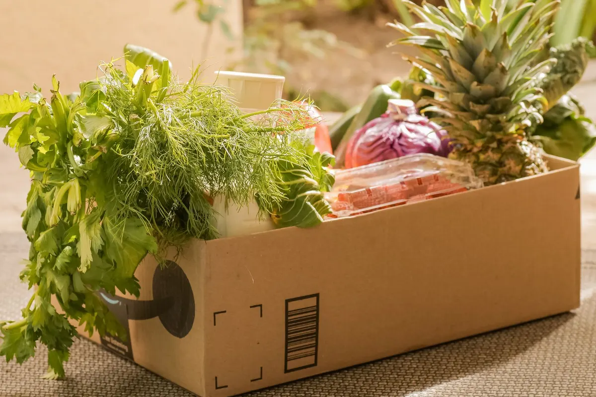 A delivery box packed with fresh vegetables and fruit