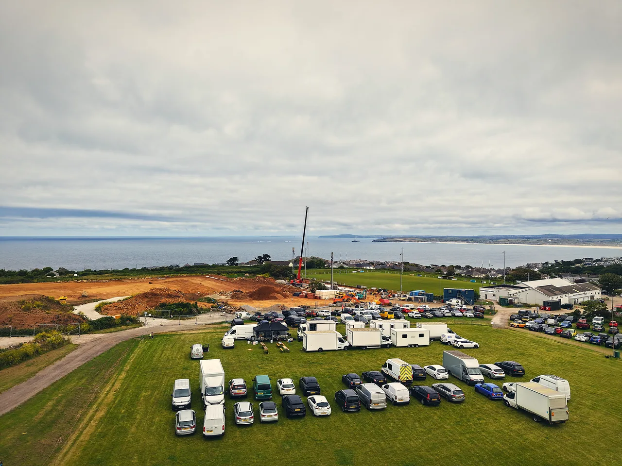 Aerial of a film unit base and crew parking overlooking the sea in Cornwall — catered by Salt Wind Catering