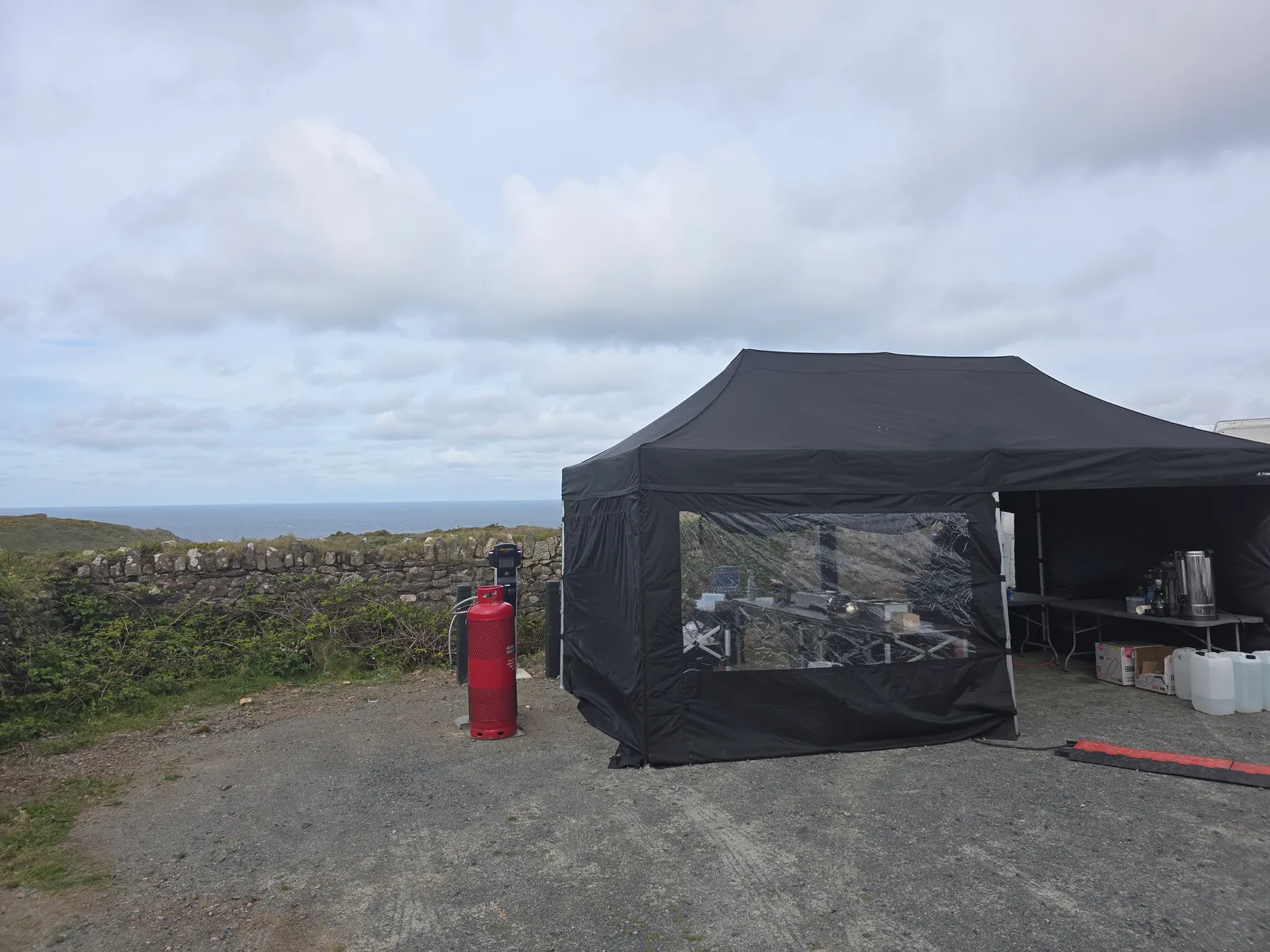 Salt Wind Catering gazebo set up beside a Cornish stone hedge above the sea, self-contained with its own gas and water