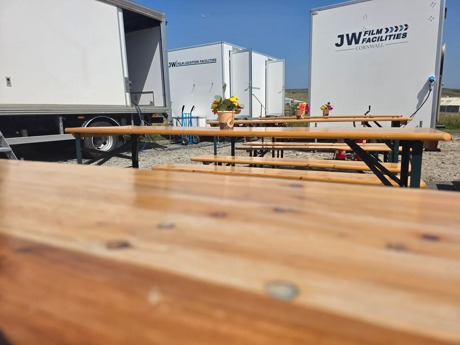 Crew dining tables set out with flowers at a Cornwall film unit base, catered by Salt Wind Catering