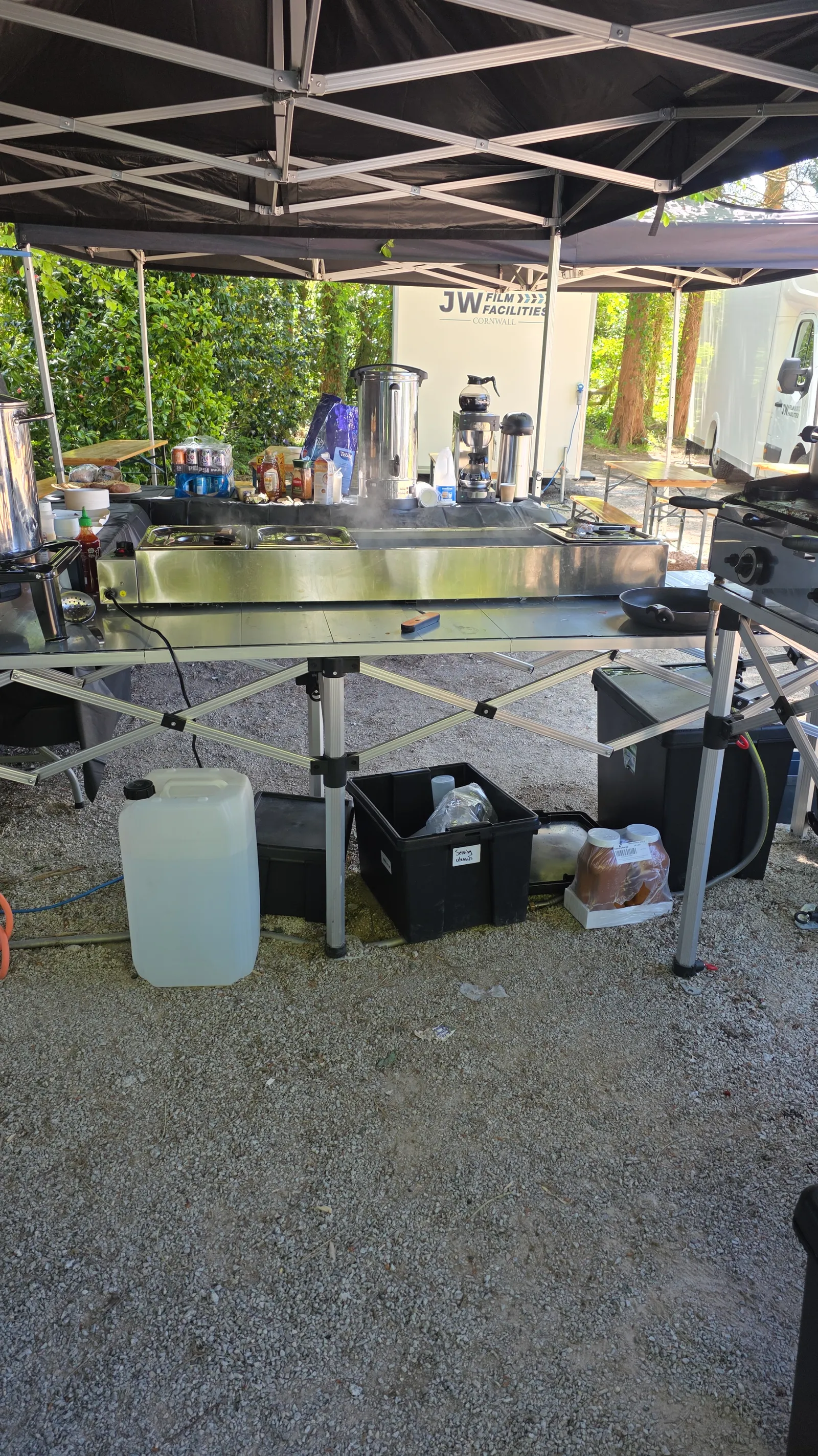 Hot food service line under the Salt Wind Catering gazebo on a Cornwall film location — bain-marie, urns and coffee