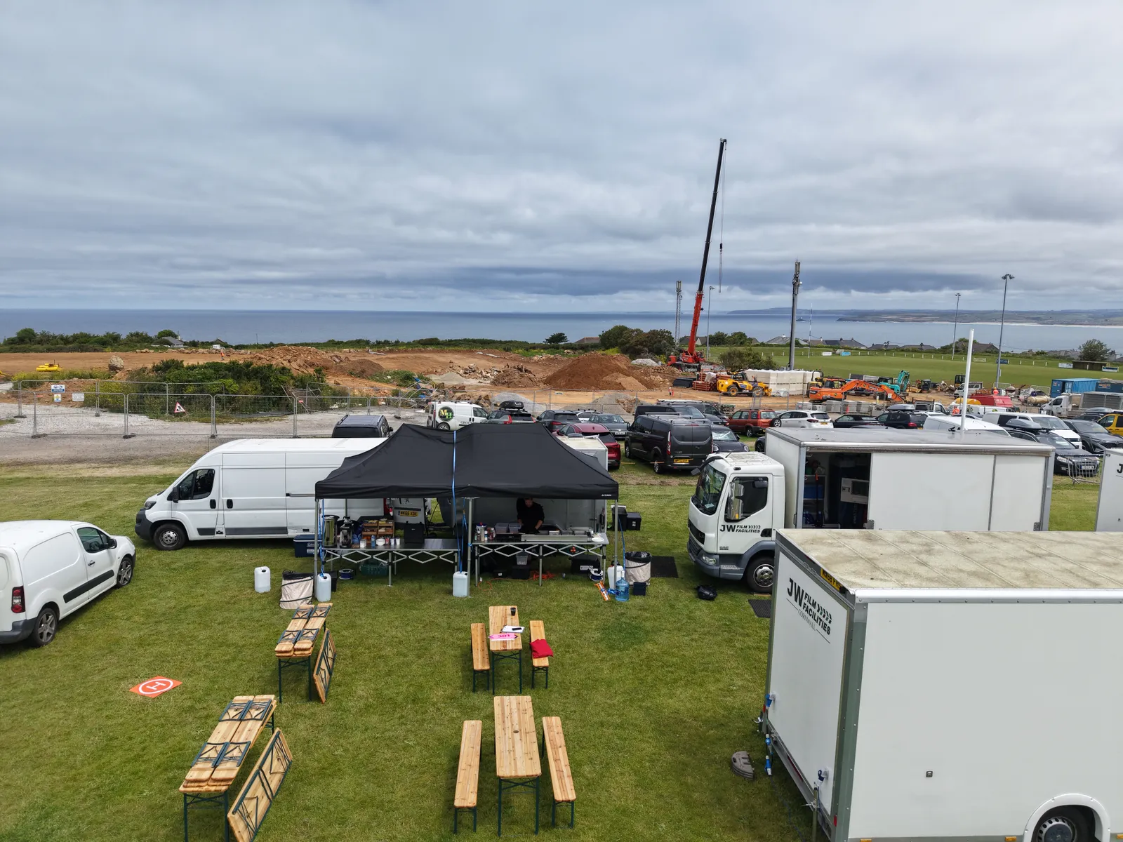 Salt Wind Catering gazebo and crew dining tables at a Cornwall unit base above the sea, alongside JW Film Facilities units
