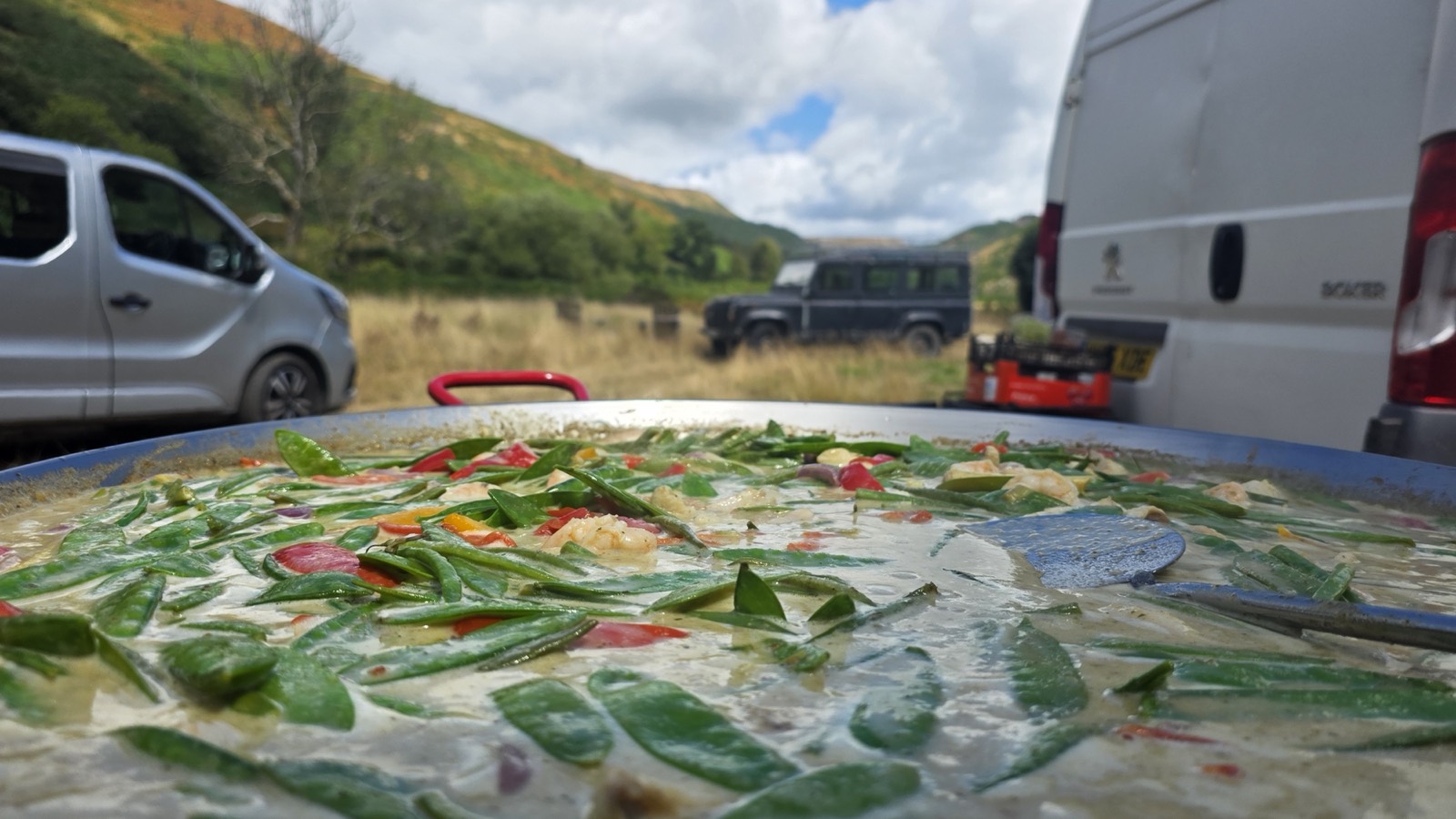 A giant pan of food cooking live on location in a Welsh valley beside the catering van